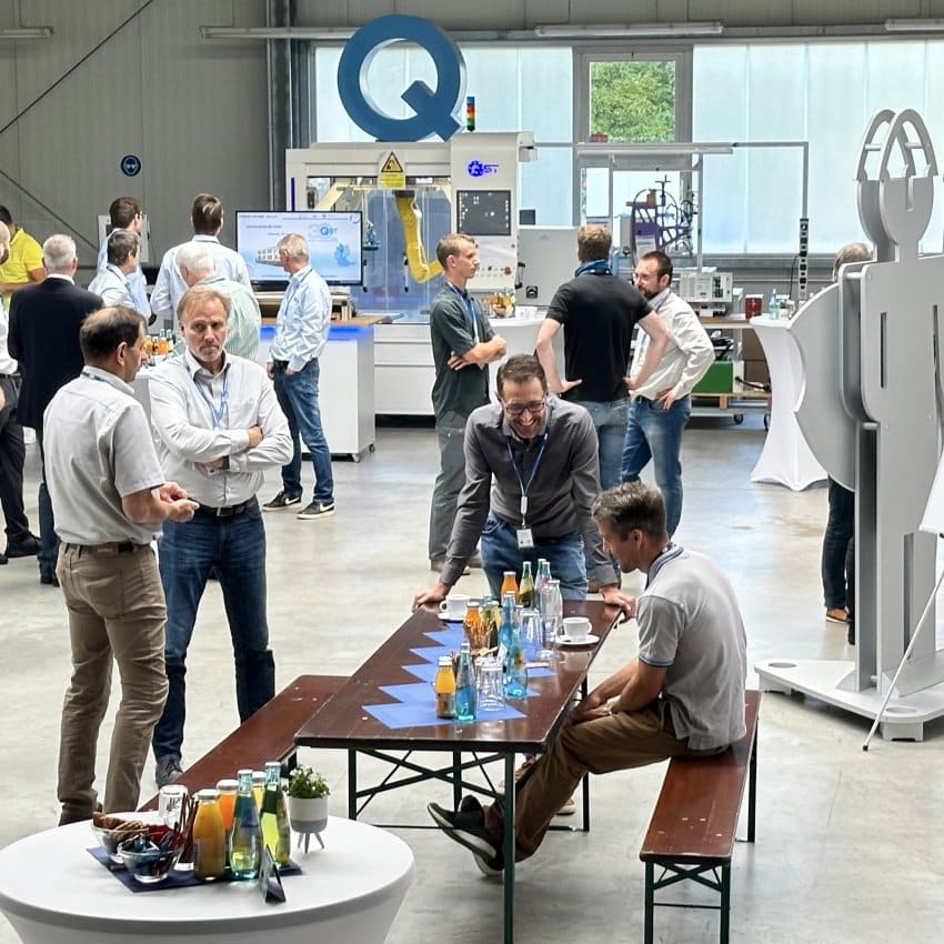 Besucher der Fachtagung stehen diskutierend in Gruppen.